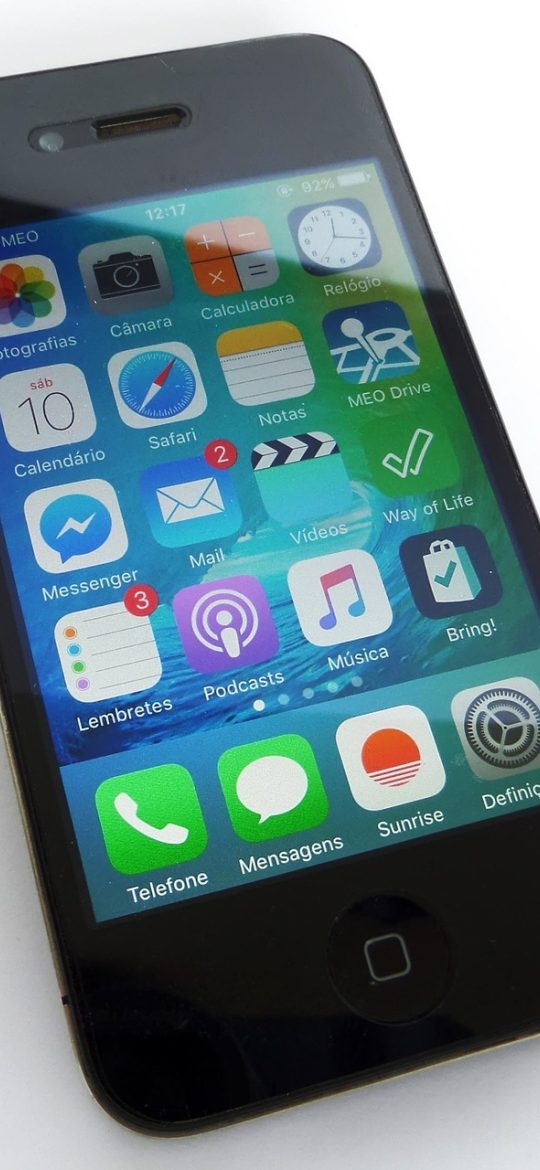 在线动漫 App 首页界面，深夜灯光下手机屏幕上排布着继续观看卡片与本周更新番剧列表